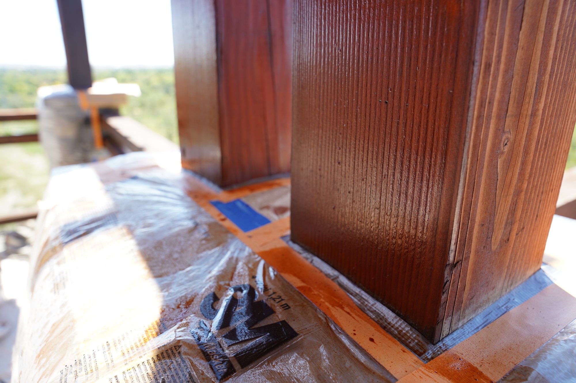 close up of a freshly stained wood beam outside of a home