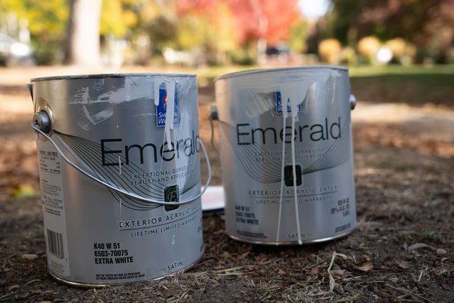 two cans of Sherwin Williams exterior paint in extra white