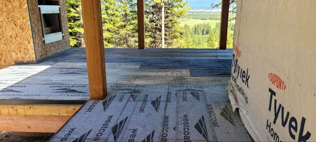 deck is being worked on outside the house and floors are covered