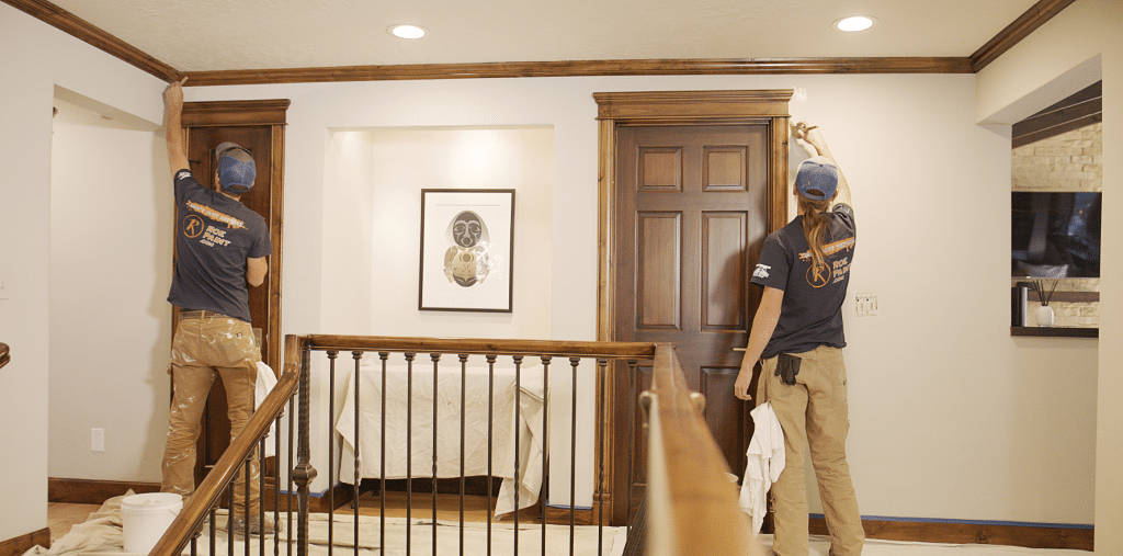 two people painting the doorway