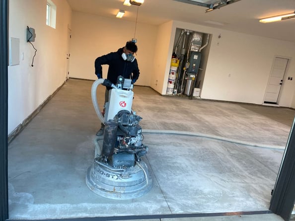 professional concrete grinder operator in a residential garage